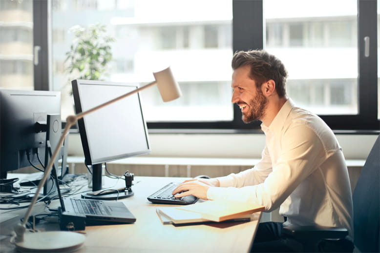 Büro-Artikel günstig online kaufen Mann sitzt an Schreibtisch
