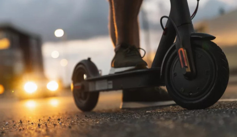 Um deinen E-Scooter im Straßenverkehr sicher nutzen zu können, musst du ein paar Dinge beachten Nahaufnahme von einem E-Scooter im Straßenverkehr