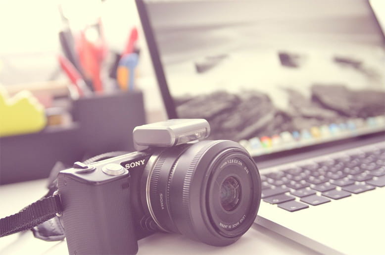 Einfach Fotos hochladen und sparen Kamera neben Laptop