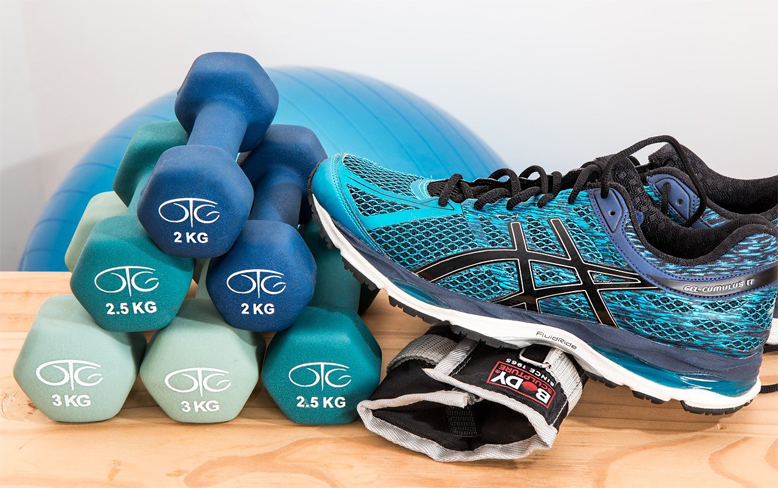 Sportzubehör Blaue Hanteln, Gymnastikball und Sportschuhe
