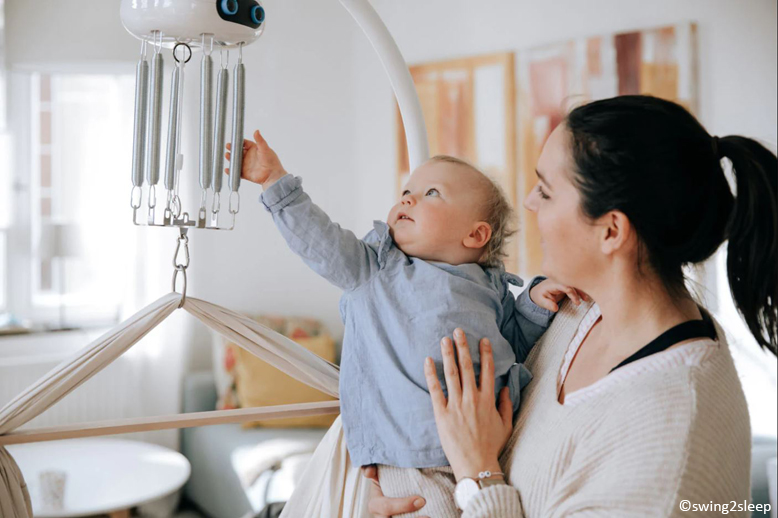 Mutter mit Baby an einer Wiege swing2sleep Wiege