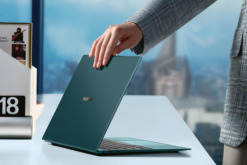 Das HUAWEI MakeBook X Pro in der Farbe 'Emerald Green' Person klappt HUAWEI MakeBook X Pro zu'